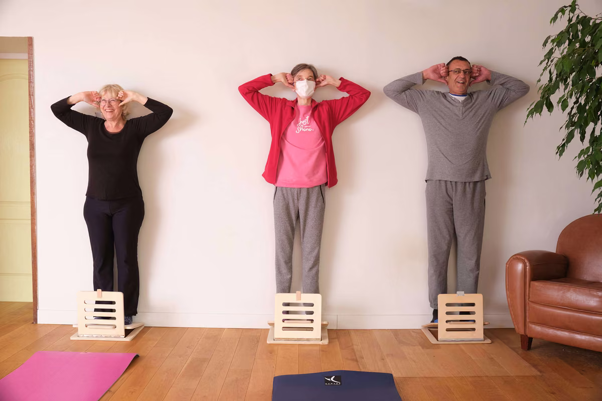 Participants à un cours d'équilibre postural, réalisant un exercice debout